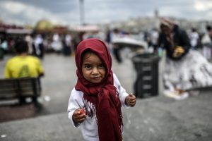 A Syrian refugee child eats food which her mother (R) collects from rubbish on August 18, 2014, at Eminonu in Istanbul. Turkey's relief agency said on August 15 it was time for the world to start "sharing the burden" of the 1.2 million Syrian refugees it is hosting, after tensions between Turks and refugees again turned violent. Hundreds of thousands of Syrian refugees have fled their country's civil war to neighbouring Turkey in the last three years after Prime Minister Recep Tayyip Erdogan -- now president-elect -- announced an open-door policy.   AFP PHOTO / BULENT KILIC        (Photo credit should read BULENT KILIC/AFP/Getty Images)